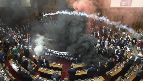 At least three Serbian lawmakers injured as smoke bombs and flares thrown in parliament