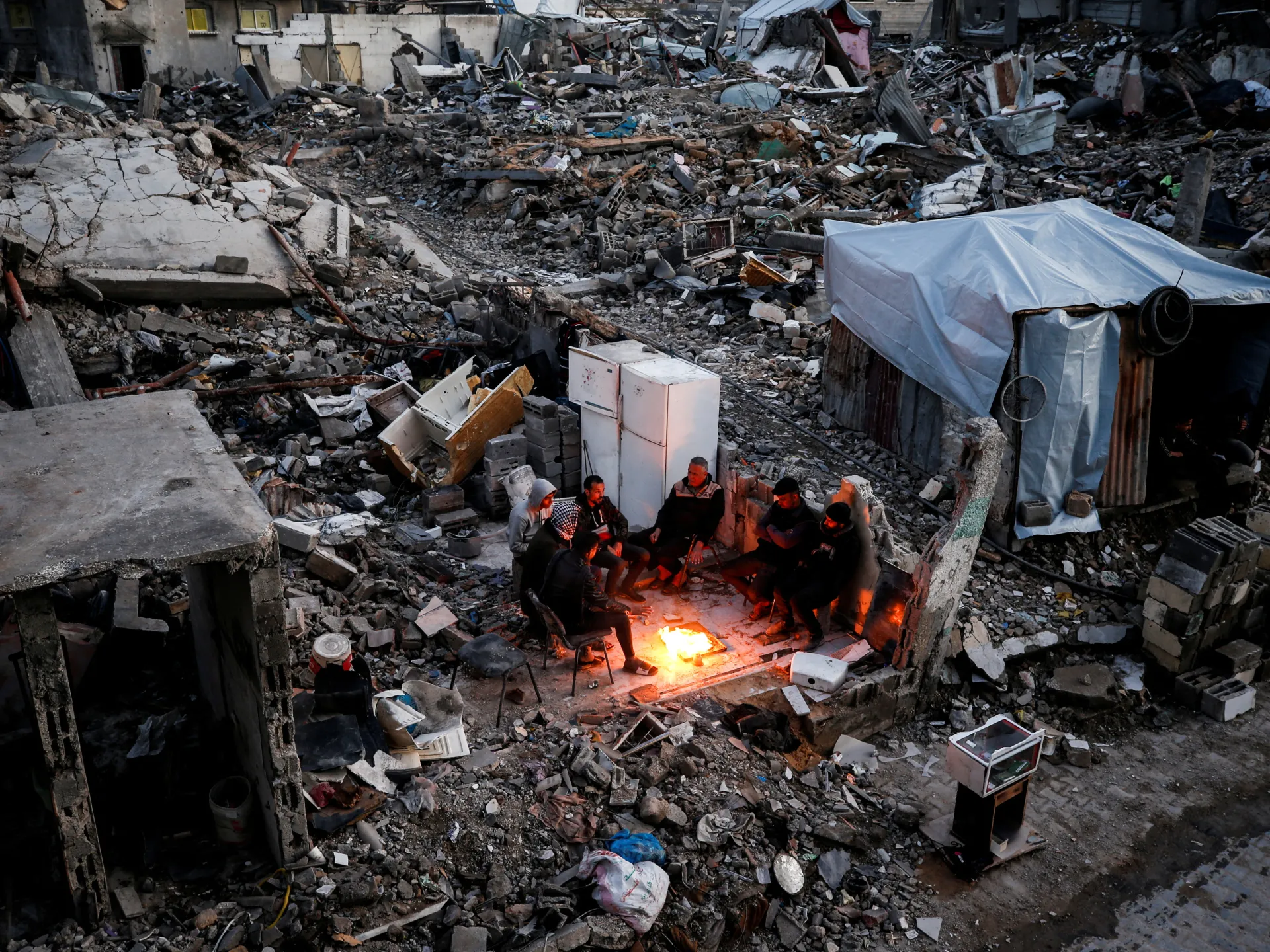 Displaced Palestinians wait for aid amid the rubble of Gaza’s destruction